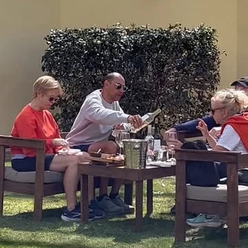 Visitantes degustando en el jardín de la bodega
